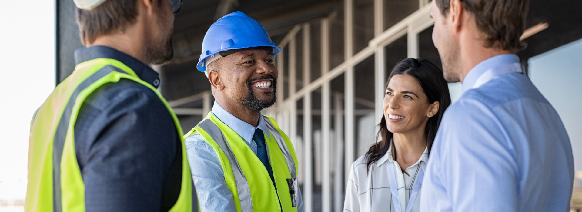 two construction workers talking to two business workers